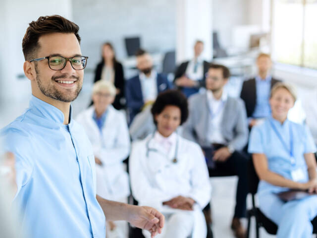 Happy businessman giving a presentation to group of colleagues a