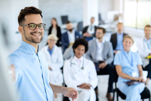Happy businessman giving a presentation to group of colleagues a